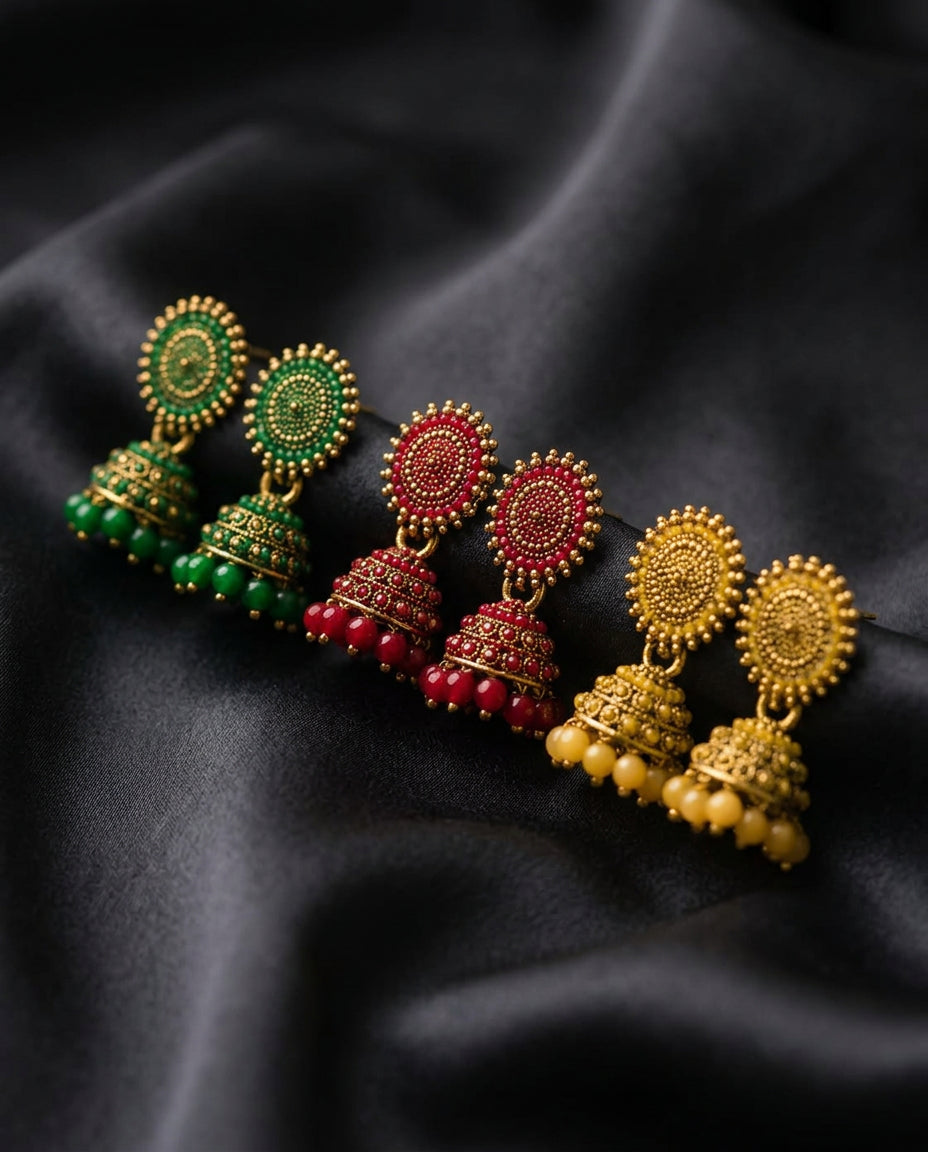 Close-up of green, red and gold beaded jhumka earrings