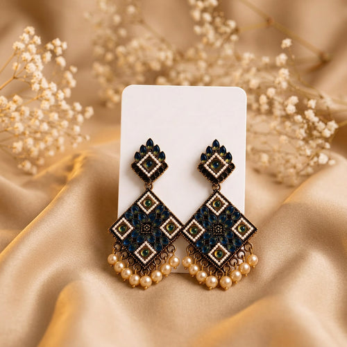 Neelam Kundan earrings on beige silk with baby's breath flowers